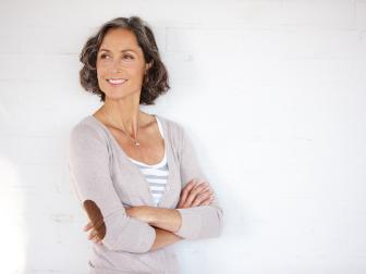 Frau steht selbstbewusst mit verschränkten Armen