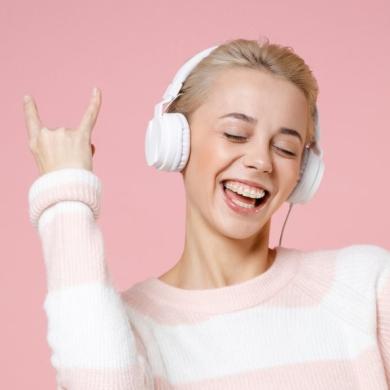 Junges Mädchen tanzt zu Musik auf Kopfhörern