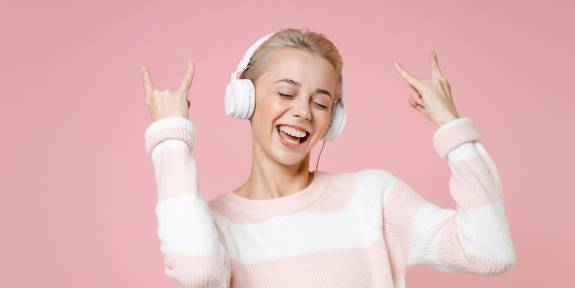 Junges Mädchen tanzt zu Musik auf Kopfhörern