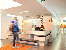 Orange-weiße, moderne Rezeption mit Blumengesteck